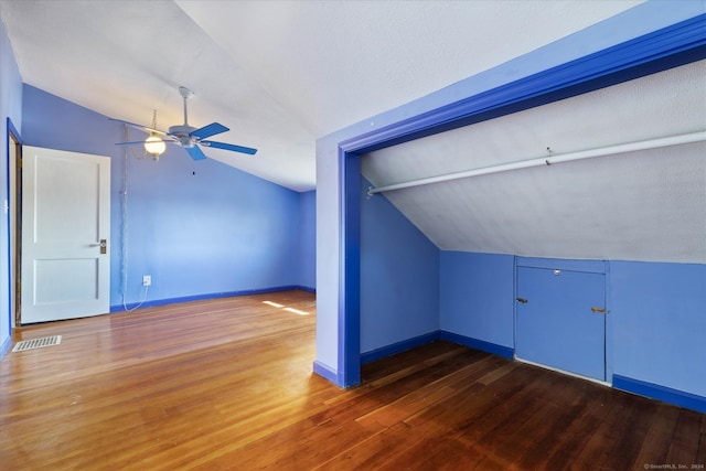 bonus room featuring lofted ceiling, ceiling fan, dark hardwood / wood-style floors, and a textured ceiling