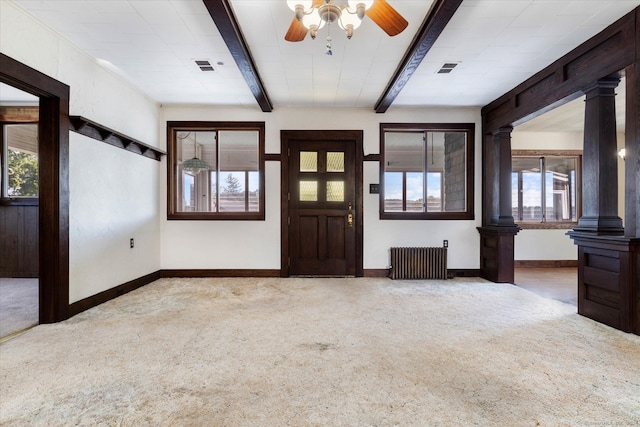 carpeted entryway featuring ornate columns, ceiling fan, radiator, and beam ceiling