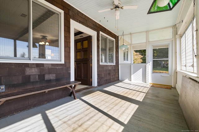 unfurnished sunroom with ceiling fan