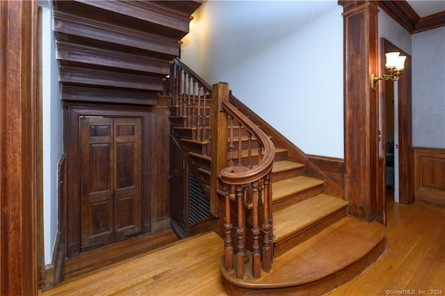 stairs featuring crown molding and hardwood / wood-style flooring