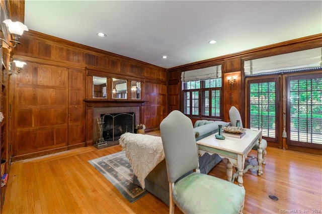 living room featuring wood walls, light hardwood / wood-style floors, and ornamental molding