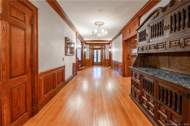 interior space with ornamental molding, light wood-type flooring, and a chandelier