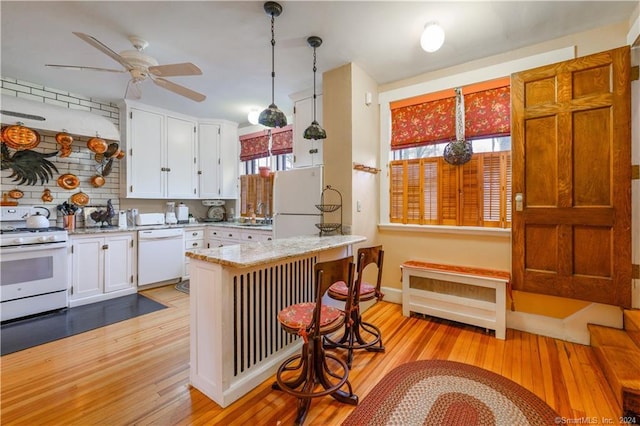 kitchen with white appliances, light stone countertops, ceiling fan, white cabinets, and light hardwood / wood-style floors