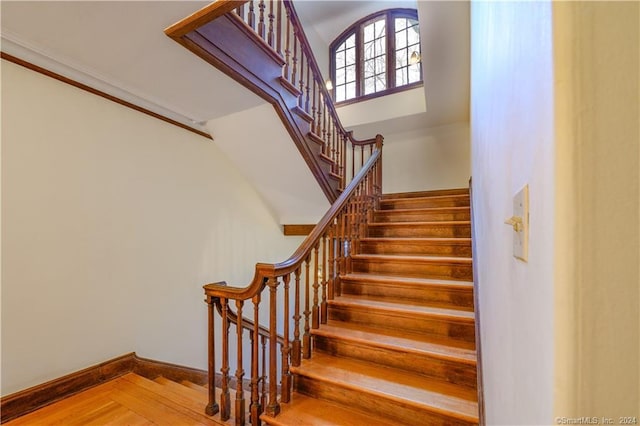 stairs featuring a high ceiling and hardwood / wood-style floors