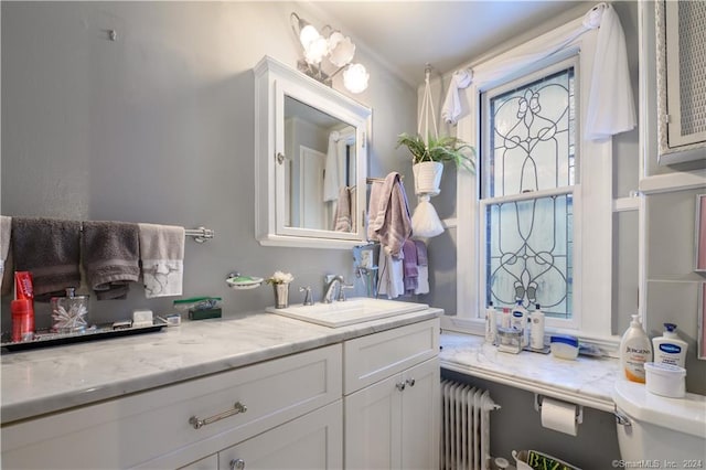 bathroom featuring radiator, toilet, and vanity