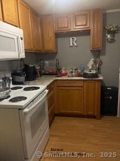 kitchen featuring white appliances, sink, and light hardwood / wood-style floors