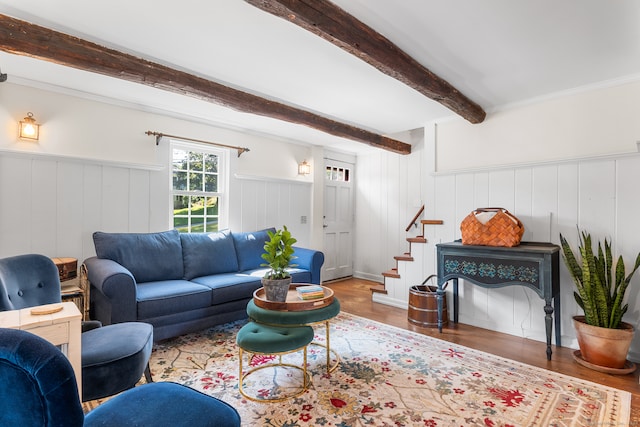 living room featuring wooden walls, beamed ceiling, and hardwood / wood-style flooring