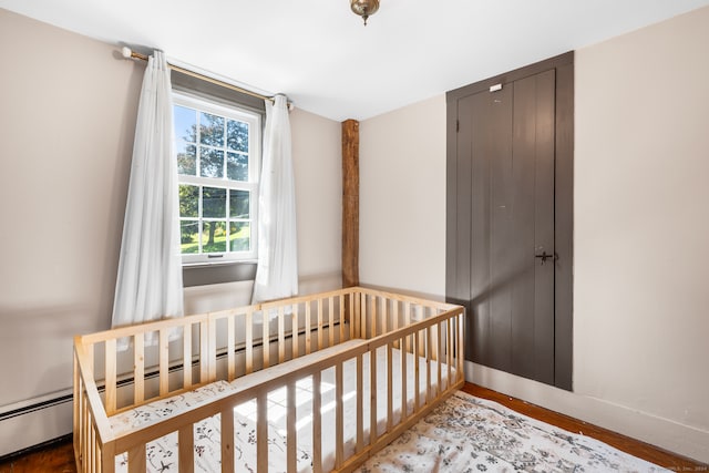 bedroom with a nursery area and hardwood / wood-style floors