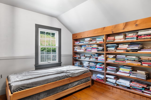 bedroom featuring wood-type flooring and vaulted ceiling