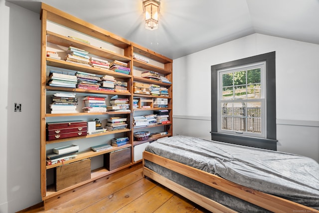 bedroom with wood-type flooring and vaulted ceiling