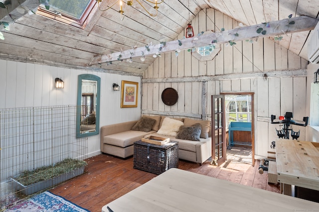 interior space with vaulted ceiling with skylight, wood walls, and hardwood / wood-style floors