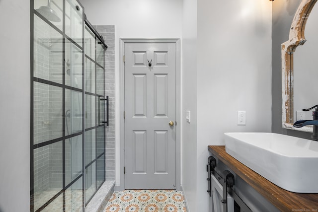 bathroom featuring a shower with shower door and vanity