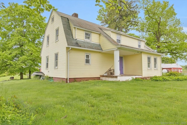 rear view of property featuring a yard