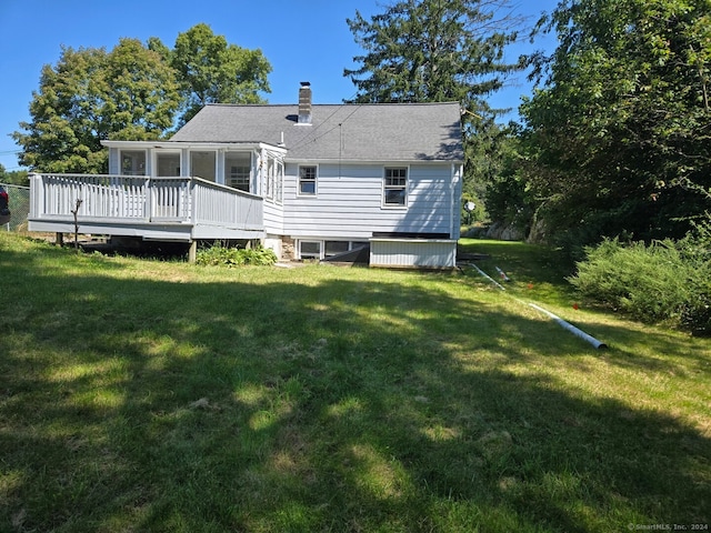 rear view of house featuring a lawn and a deck