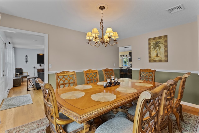 dining area featuring an inviting chandelier and light wood-type flooring