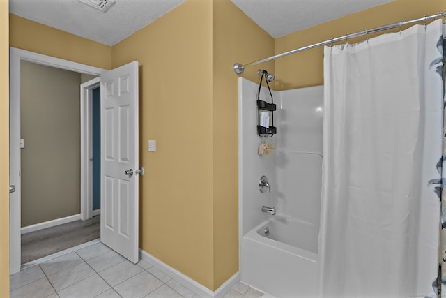 bathroom featuring a textured ceiling, shower / bath combo, and tile patterned flooring