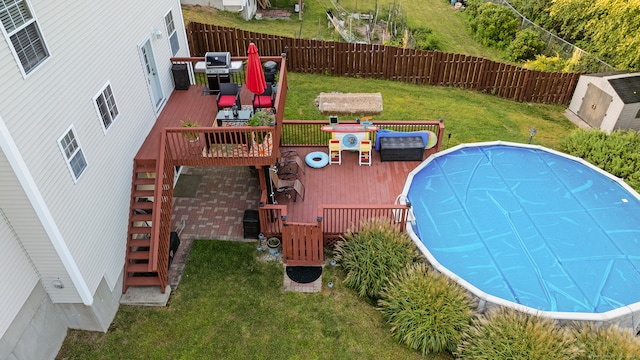 view of pool featuring a deck and a lawn