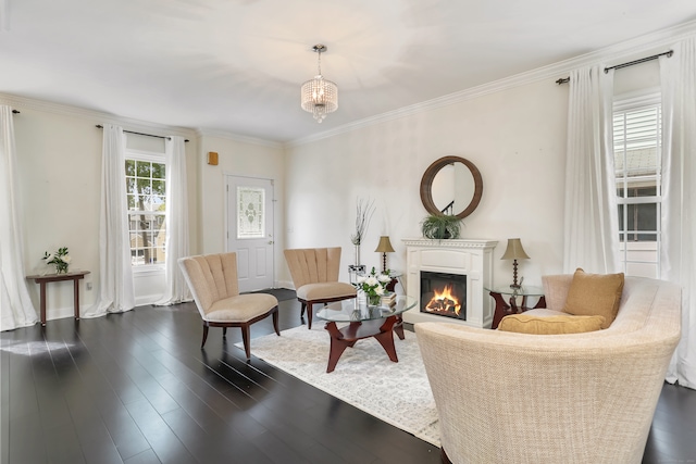 sitting room with ornamental molding, dark hardwood / wood-style floors, and an inviting chandelier