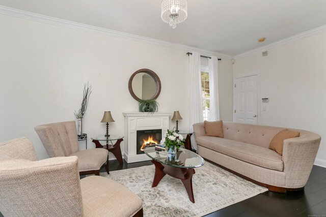 living room featuring wood-type flooring, crown molding, and a notable chandelier