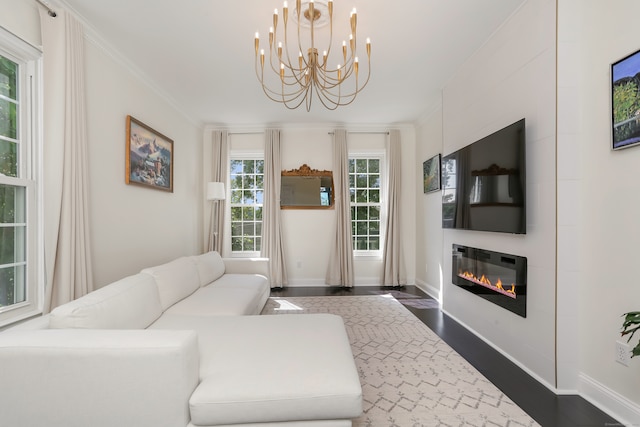 living room with dark wood-type flooring, ornamental molding, and a chandelier