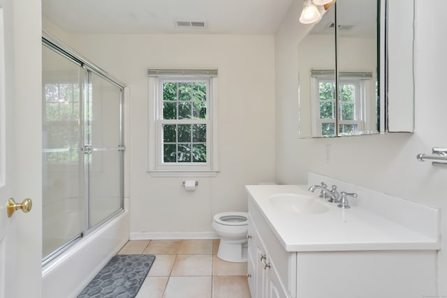 full bathroom featuring shower / bath combination with glass door, vanity, toilet, and a healthy amount of sunlight