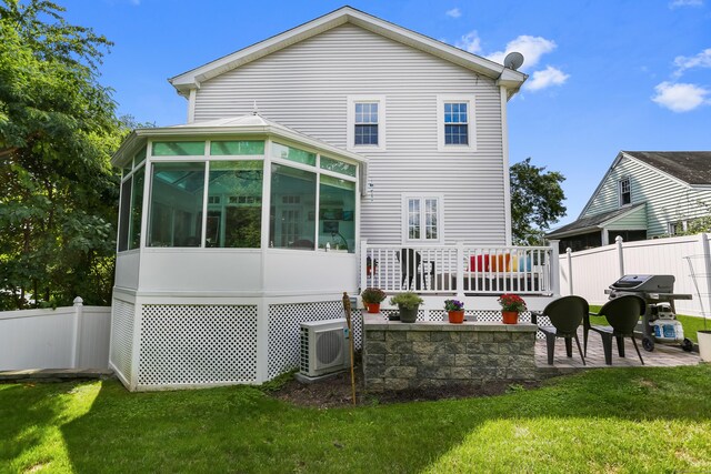 back of house with ac unit, a sunroom, a lawn, and a patio