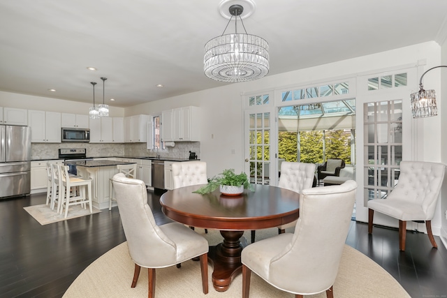 dining space featuring sink, a notable chandelier, and dark hardwood / wood-style floors