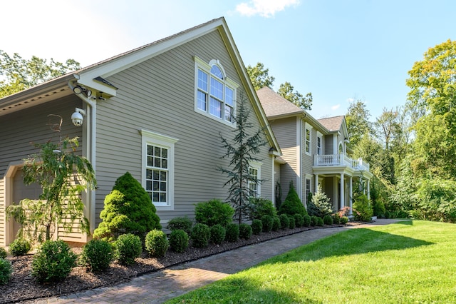 view of front facade with a balcony and a front yard