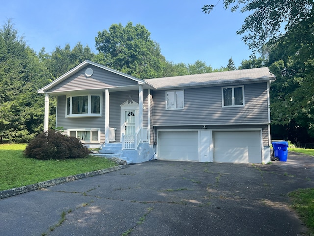 bi-level home featuring a garage and a front lawn