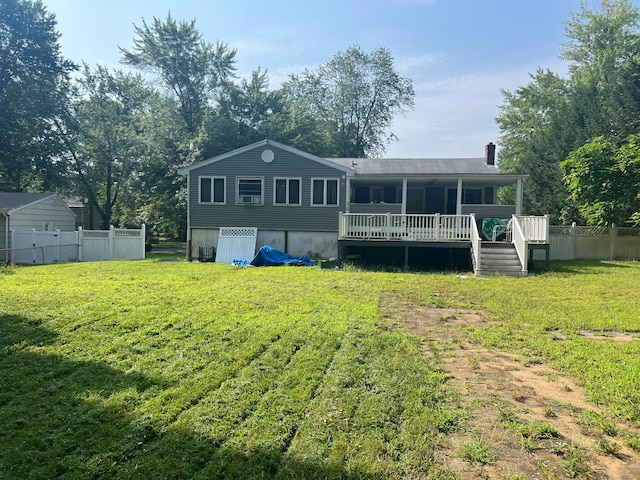 rear view of house featuring a lawn and a deck