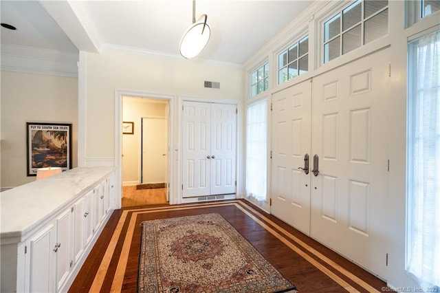 entryway featuring dark hardwood / wood-style flooring and ornamental molding