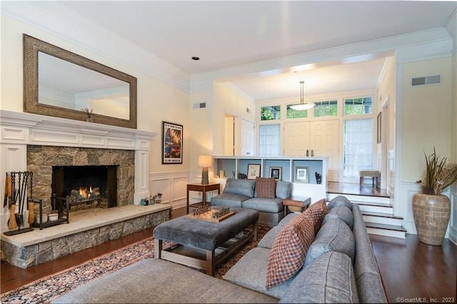 living room with a fireplace, dark hardwood / wood-style flooring, and ornamental molding