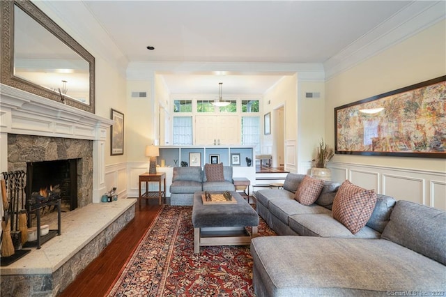 living room with ornamental molding, dark wood-type flooring, and a premium fireplace