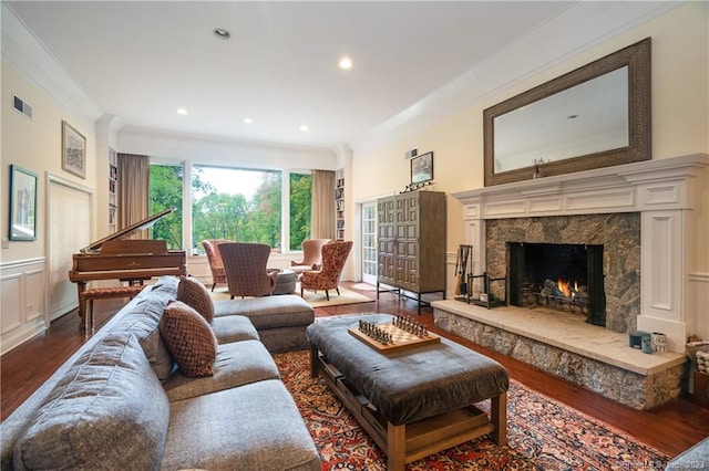 living room featuring ornamental molding, a high end fireplace, and dark hardwood / wood-style floors