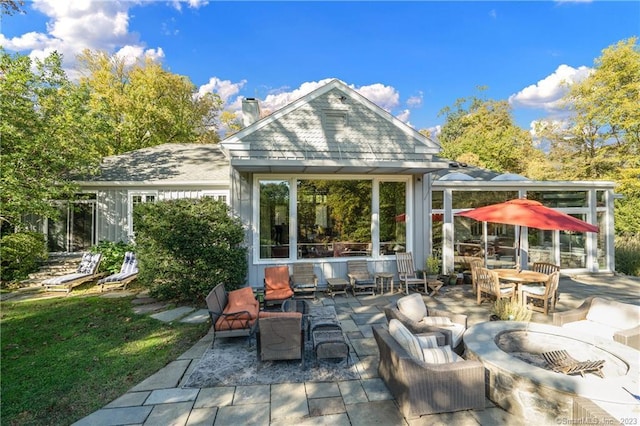 rear view of house featuring a patio area and an outdoor living space with a fire pit