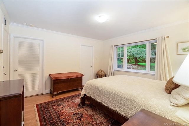 bedroom featuring light wood-type flooring and ornamental molding