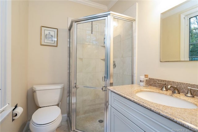 bathroom featuring ornamental molding, vanity, toilet, and a shower with shower door