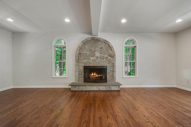 unfurnished living room with hardwood / wood-style flooring, a fireplace, and beam ceiling