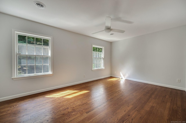 empty room with dark hardwood / wood-style flooring and ceiling fan