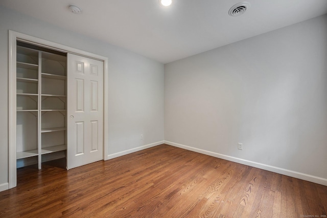 unfurnished bedroom with hardwood / wood-style flooring and a closet