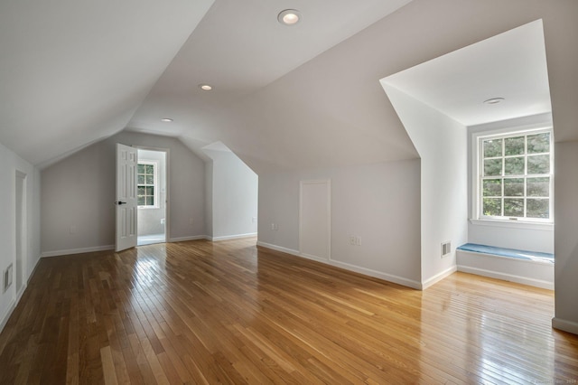 bonus room with vaulted ceiling and light hardwood / wood-style floors