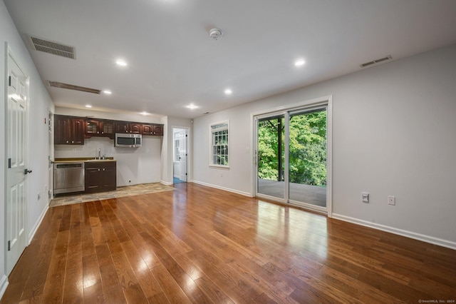 unfurnished living room with hardwood / wood-style floors and sink