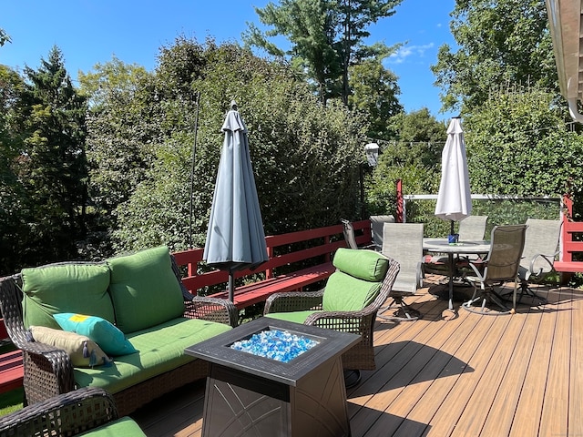 deck with an outdoor living space with a fire pit