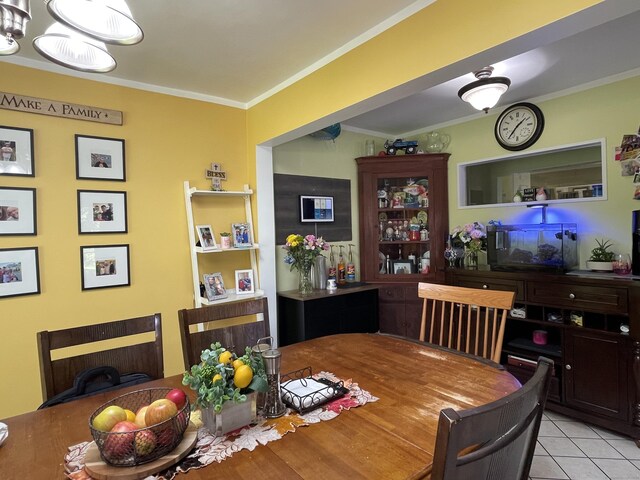 dining room featuring light tile patterned floors, an inviting chandelier, and ornamental molding