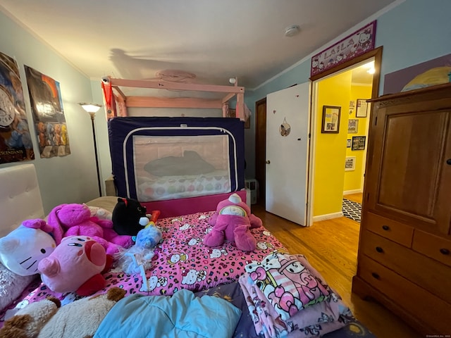 bedroom with wood-type flooring and ornamental molding