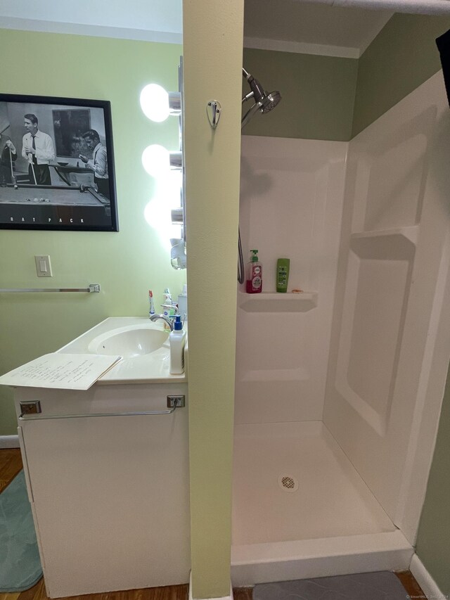 bathroom with vanity, hardwood / wood-style flooring, and walk in shower