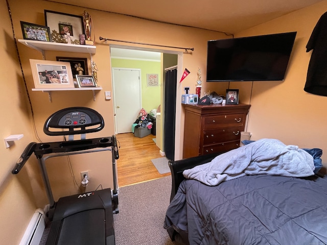 bedroom featuring baseboard heating and light hardwood / wood-style floors