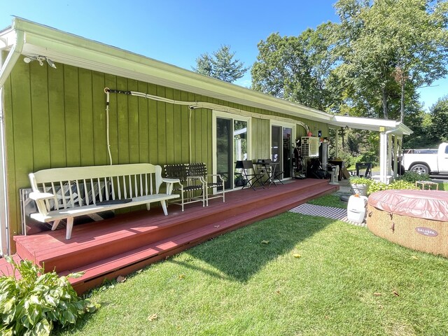 rear view of property featuring a deck and a lawn