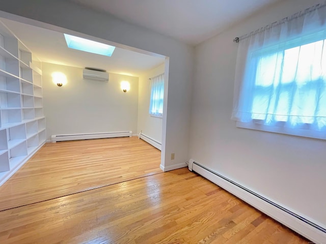 25 Old Middle Rd, Brookfield, CT 06804 - empty room with a baseboard radiator, an AC wall unit, a skylight, and wood finished floors