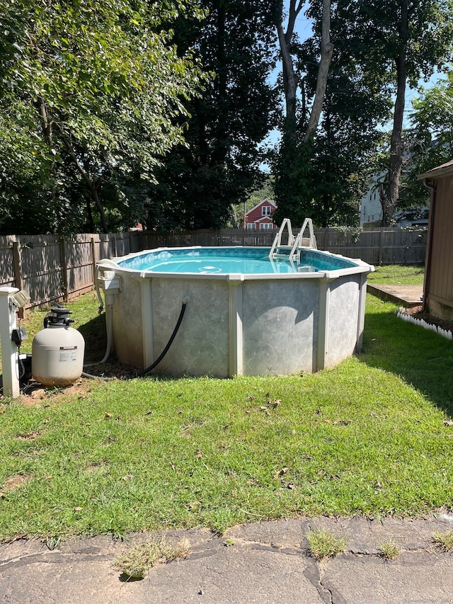 view of pool with a lawn